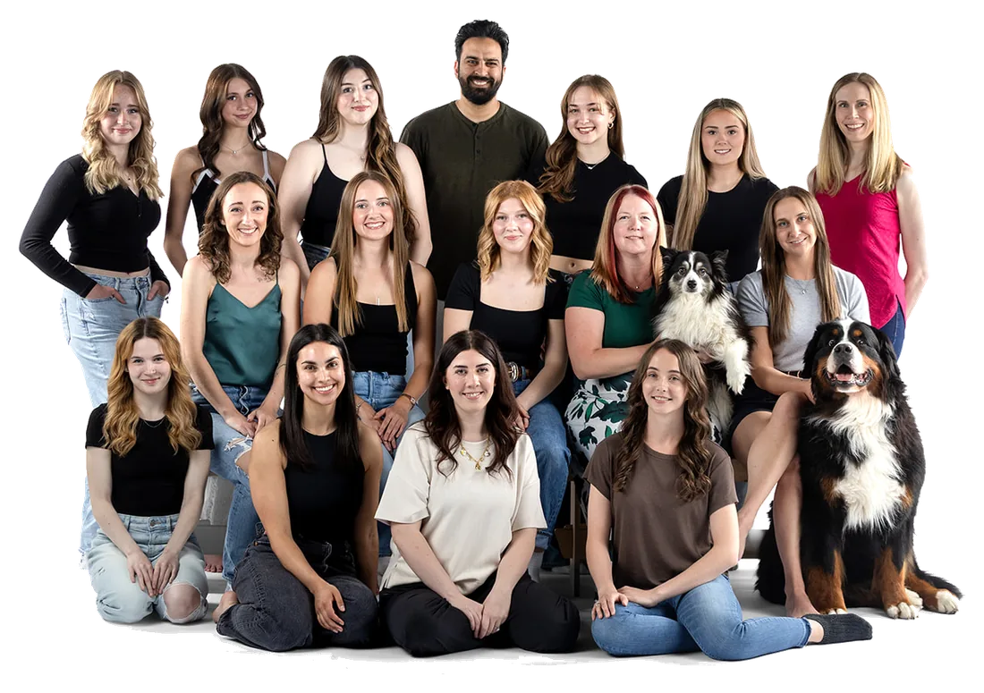 The Taryn’s Dance Company teaching staff and studio team photographed together, seated and standing in three rows with the studio’s two dogs.